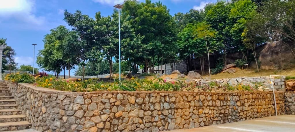 Nairuthya Whispering Wood — Stone terraces and landscaped boundary retaining walls